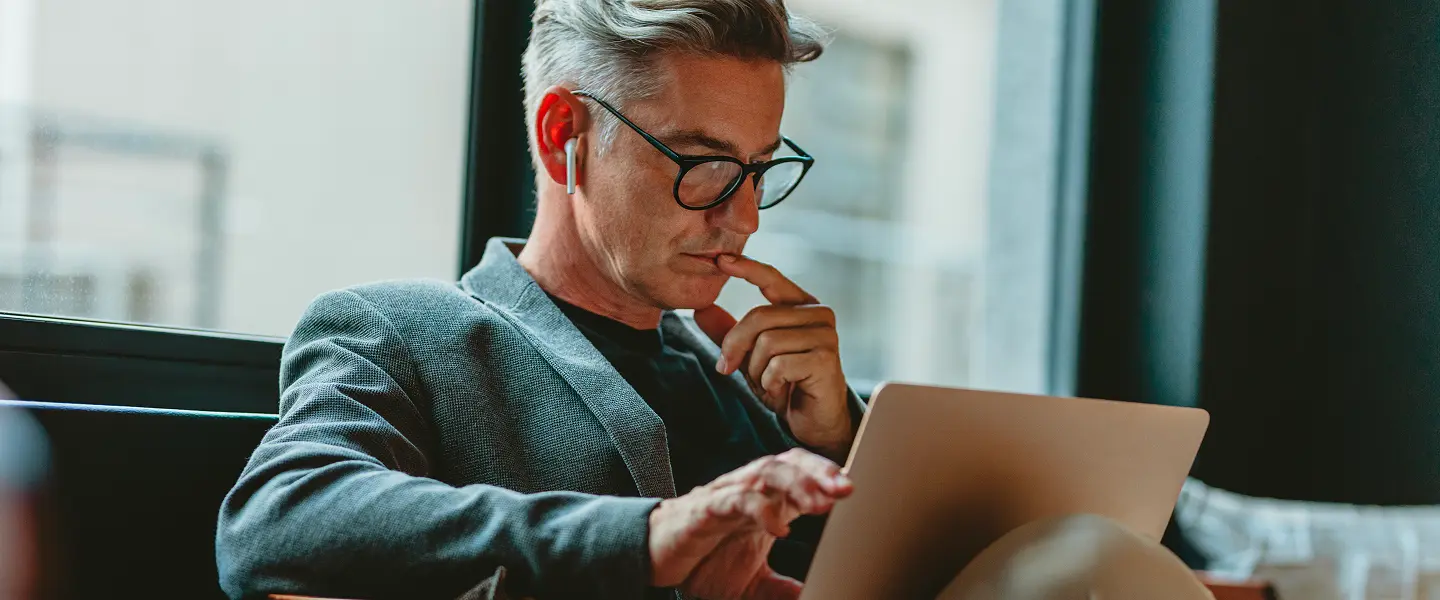 un uomo d'affari sta lavorando al computer portatile mentre indossa le sue cuffiette