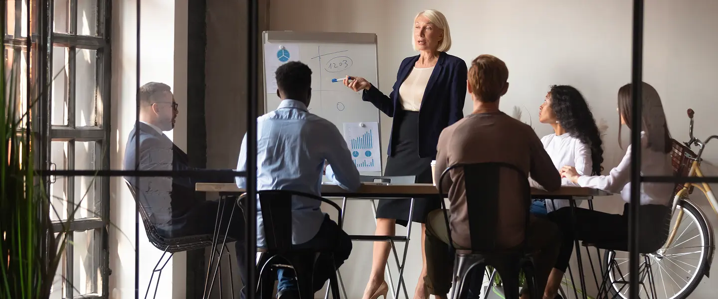 c'è una riunione in corso e chi la presiede sta mostrando dei grafici